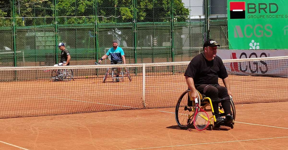 Men play wheelchair tennis in an ITF tournament