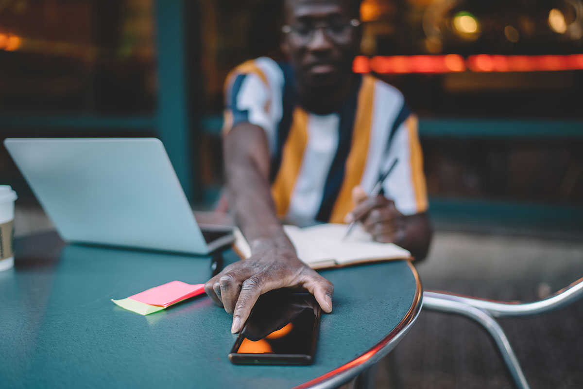 A man reaches to check his smartphone