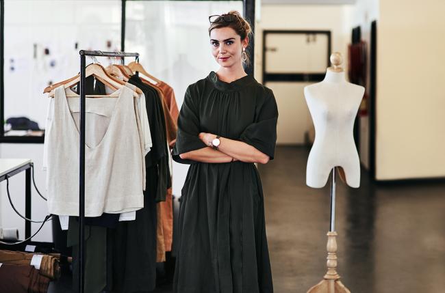 Woman standing next to clothing rack