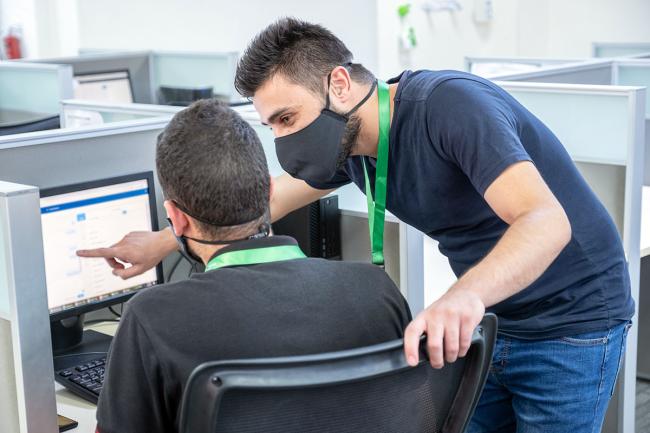 Call center trainer and employee in masks