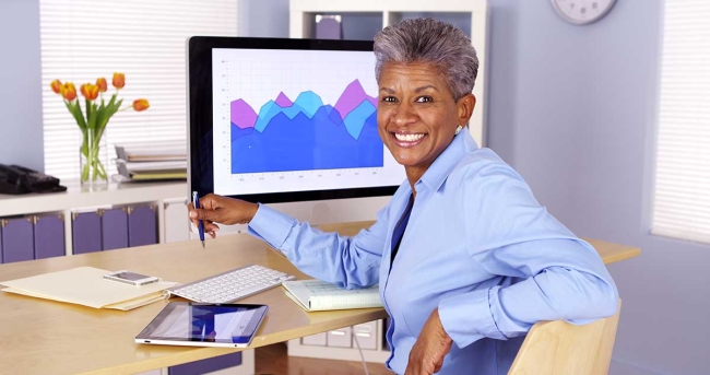 Executive at desk with tablet and computer