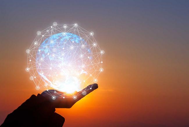 Be a differentiator and stand out with bright ideas A hand in silhouette holds a lighted globe