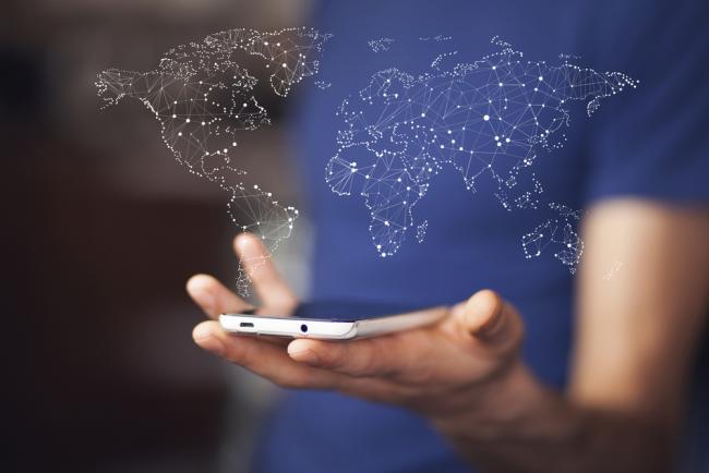 Man holding smartphone with world map