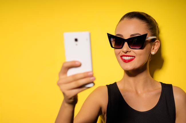 Fashionable influencer taking a selfie with her new stylish sunglasses on