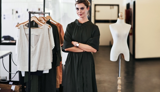 Woman standing next to clothing rack
