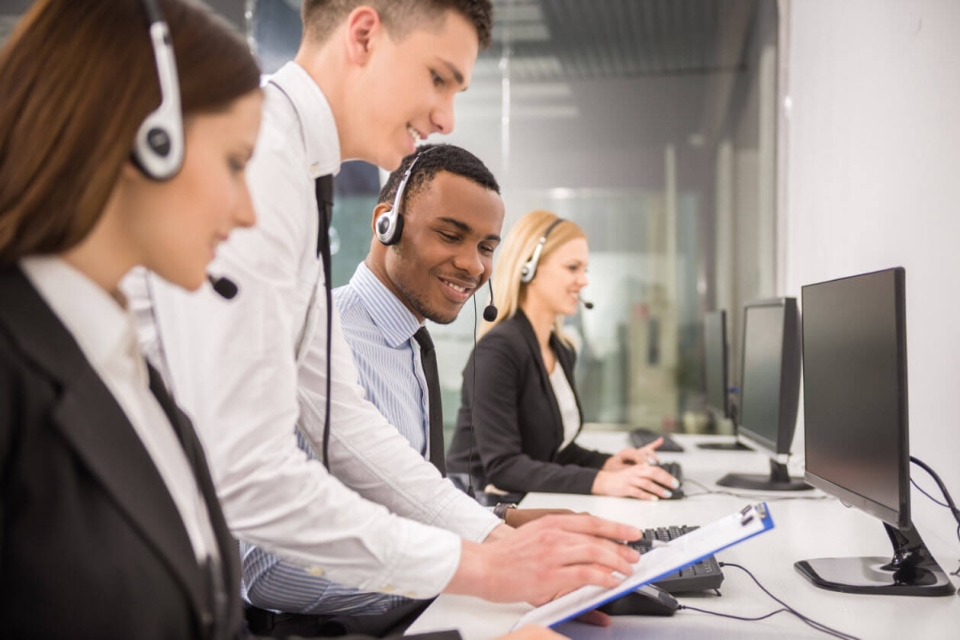 A man training a new outsourced team of call agents