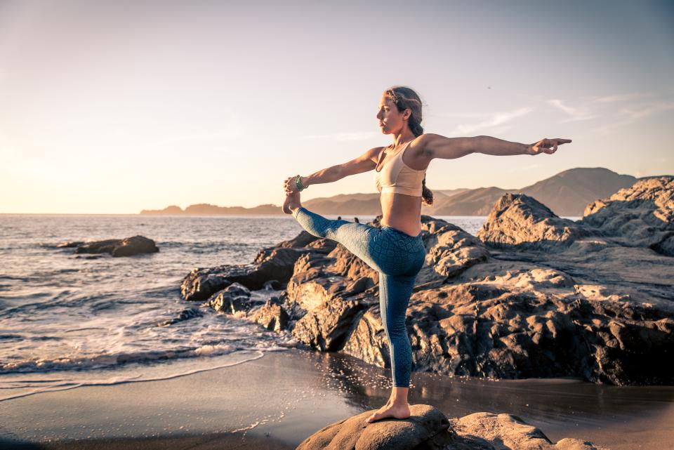 Woman doing yoga on the beach